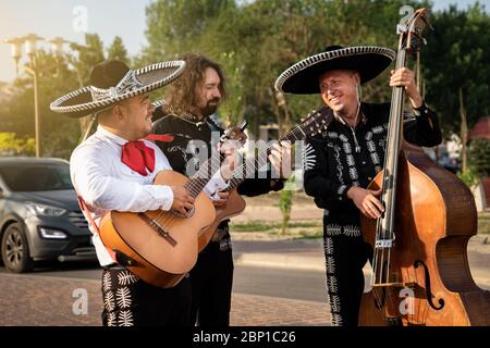 Mexican musicians play musical instruments in the city. City street in the summer. Stock Photo