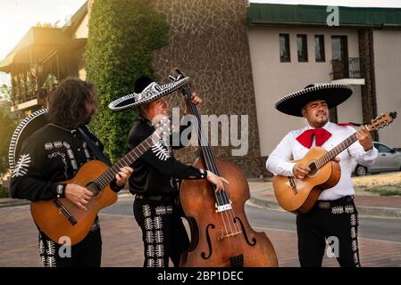 Mexican musicians play musical instruments in the city. City street in the summer. Stock Photo