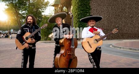 Mexican musicians play musical instruments in the city. City street in the summer. Stock Photo