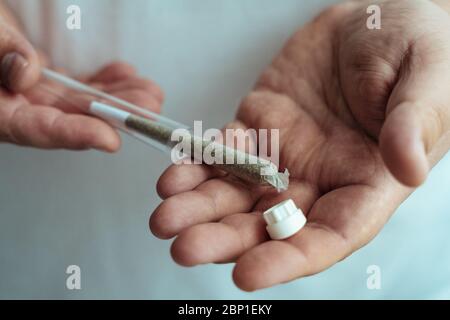 Weed joint in plastic tube in male hand. Marijuana or Cannabis ready to smoke. Amsterdam famous legal drug. Stock Photo