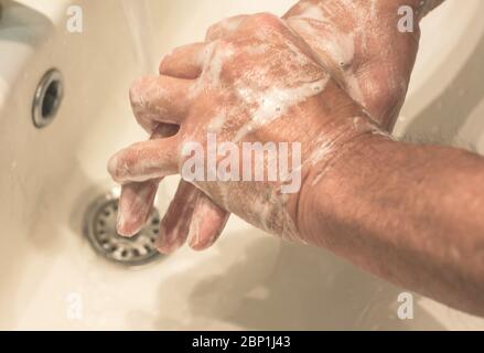 mature man washes the hands to herself with fluent water and soap. Protection from infection. wash your hands against the virus Stock Photo
