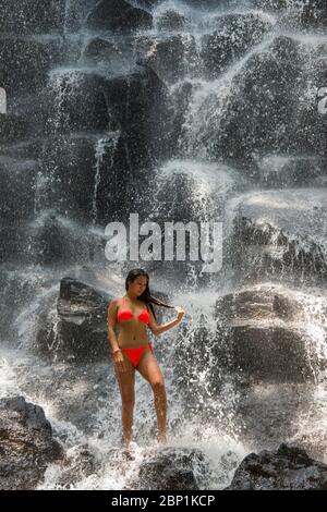 Girl standing in Kanto Lampo Waterfall near Ubud Bali Indonesia Stock Photo