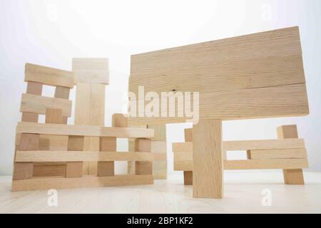 Building from wooden cubes and rods. The photo was taken on the white background and on the table. Close up. Stock Photo