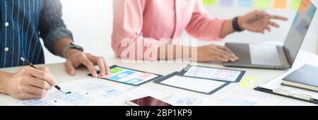 Graphic designers team work together with UX UI designer planning application template layout mobile phone prototype, User experience concept. Stock Photo