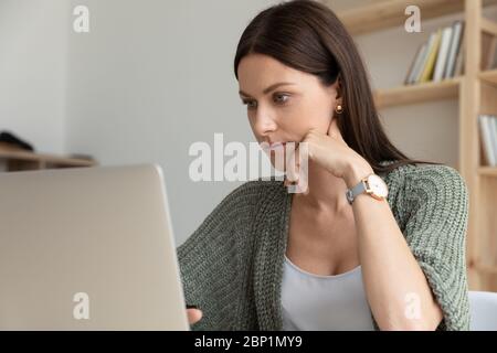 Close up confident young businesswoman holding chin thinking about project. Stock Photo