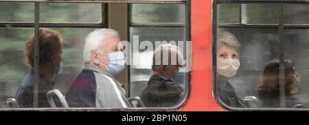 Belgrade, Serbia - May 15, 2020: People wearing surgical face masks while  sitting and riding in a window seat of a tram, from outside Stock Photo