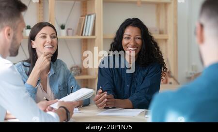 Happy african american businesswoman telling employees about project. Stock Photo