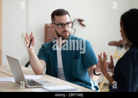 Serious businessman perplexed by female colleague decision in office. Stock Photo
