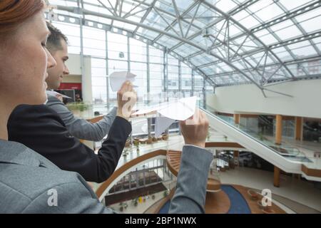 Team of business people throwing together paper planes in modern office building Stock Photo