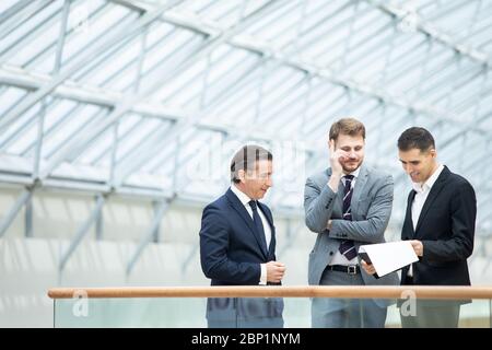 Business people having informal meeting in modern office discussing documents Stock Photo
