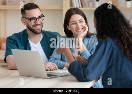 Real estate agent consulting happy young couple about buying house. Stock Photo