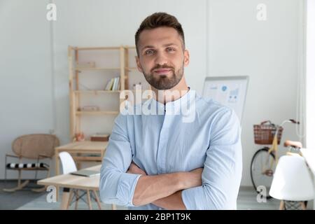 Close up headshot portrait picture of smiling businessman crossing hands. Stock Photo
