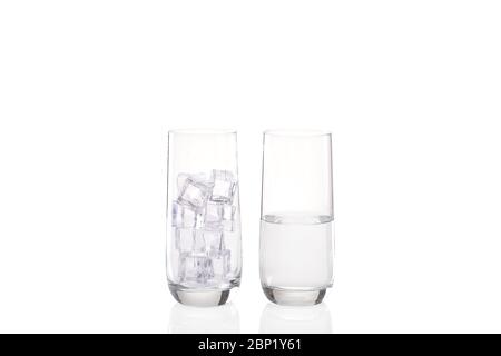 Ice melting concept with one glass full of ice and a second image of another glass half full of water showing the melted ice Stock Photo