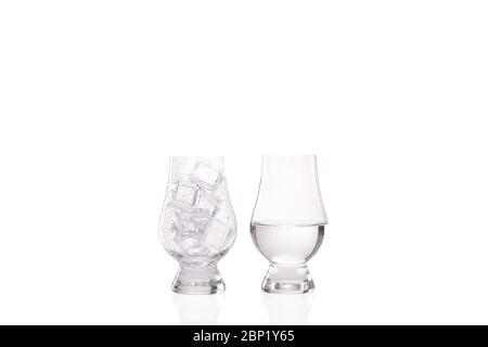 Ice melting concept with one whisky glass with condensation droplets on the outside and full of ice and a second image of another whisky glass half fu Stock Photo