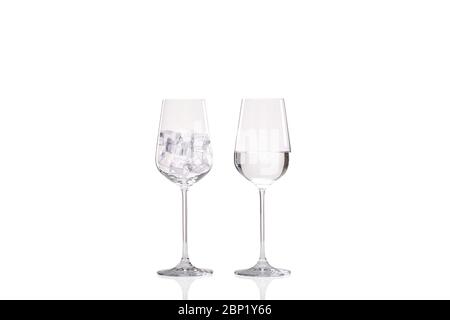 Ice melting concept with one wine glass full of ice and a second image of another wine glass half full of water showing the melted ice Stock Photo