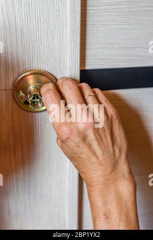 man repairing the doorknob. closeup of worker's hands installing new door locker Stock Photo