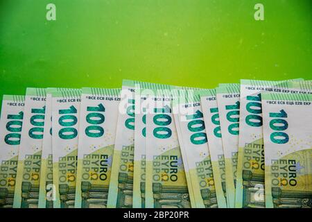 Stack of hundreds of euro banknotes on bright green background with copy space Stock Photo