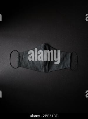 Black mask on black background flat lay. Pollution prevention mask. Corona and covid-91 virus protection. Free space for your text Stock Photo