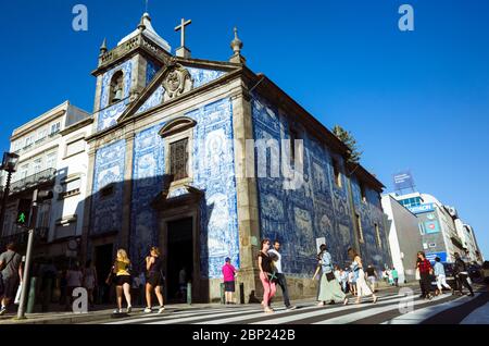 Porto, Portugal : People walk past the blue azulejo adorned walls of the Capela das Almas chapel. Stock Photo