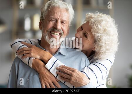 Loving middle aged married couple spending time together at home. Stock Photo