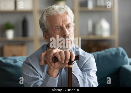Upset middle aged mature grandfather thinking of disability. Stock Photo
