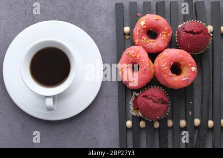 Top view of donuts and coffee on black background  Stock Photo