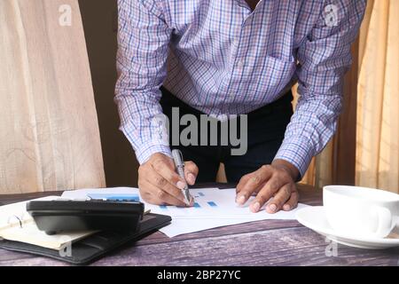 The concept of working from home. businessman analyzing financial data on desk, Stock Photo
