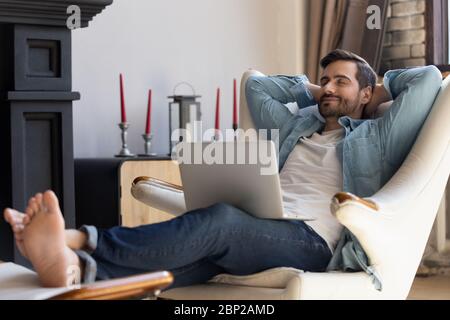 Millennial man relax in comfortable chair at home Stock Photo