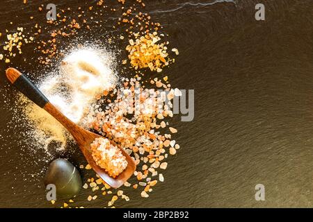 Different types of salt on a slate board. Spices to food. Stock Photo