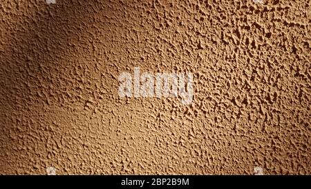 Brown rough plaster wall texture closeup with vignetting of sunlight and shadow. Abstract textured background with copy space Stock Photo