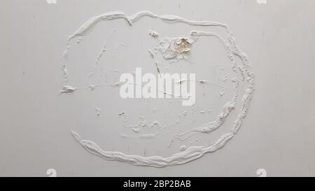 White stucco wall with round shape cracks of flaking paint and surface damaged by humidity. Building wall needed repaint. Reconstruction background wi Stock Photo