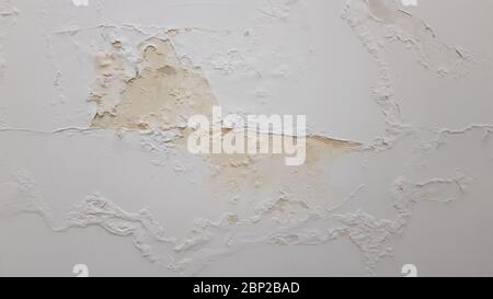 Old stucco wall with flaking paint and yellow surface damaged by humidity. Building wall needed repaint. Reconstruction background with copy space Stock Photo