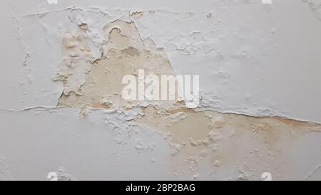 Painted stucco wall with flaking paint and surface ruined by humidity. Building wall needed repaint. Reconstruction background with copy space Stock Photo