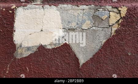 Weathered wall surface closeup with damaged peeling layer and cracked cement surface underneath. Building wall needs repair. Reconstruction background Stock Photo
