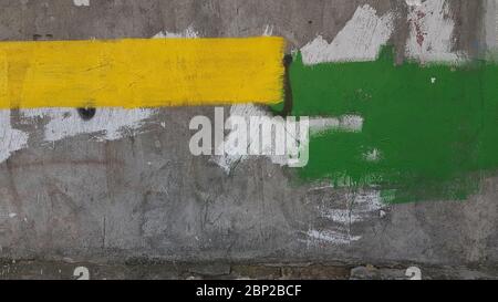 Old rough cement wall with rectangle stains of yellow and green stains. Abstract background of construction repair industry Stock Photo