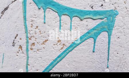 Strokes of light blue paint on scratched white stucco wall surface. Closeup of blue dripping paint. Abstract painted background with copy space Stock Photo