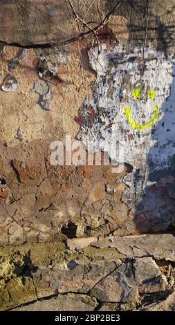 Weathered wall texture of abandoned house. Damaged limestone wall and cracked stucco surface. Grunge building wall needs renovation Stock Photo