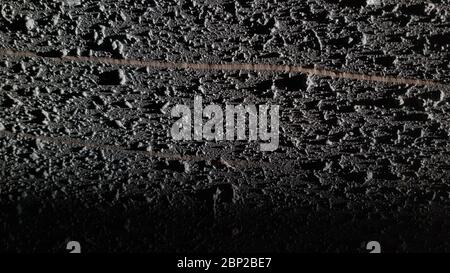 Scratched rough texture of dark wall surface closeup. Straight line of scratch on textured grey plaster wall Stock Photo
