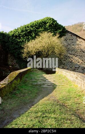 End of the road, a pathway that ends at an old stone house in the countryside of England Stock Photo