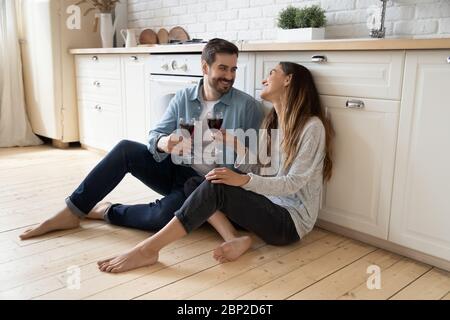 Happy couple sit on floor having romantic date at home Stock Photo