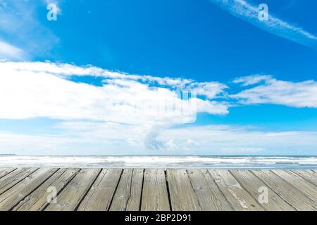 empty wooden deck table top Ready for product display montage with sea,blue sky and beach background.. Stock Photo