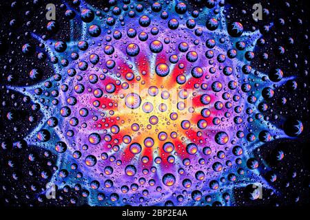 multi-colored mandala through drops of water on glass Stock Photo