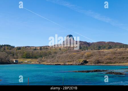 The Isle of Eigg and the towering Ann Sgurr seen from the ferry arriving at the harbour. Stock Photo