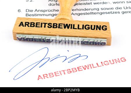 Ein Stempel aus Holz liegt auf einem Dokument. Aufschrift Arbeitsbewilligung