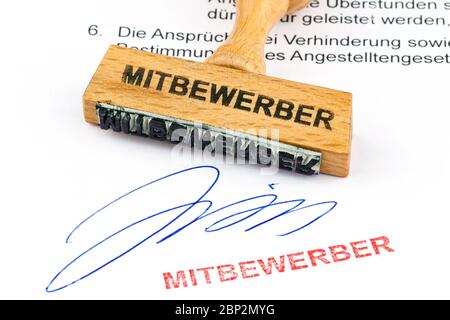 Ein Stempel aus Holz liegt auf einem Dokument. Aufschrift Mitbewerber