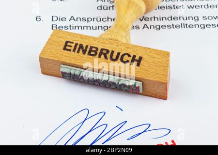 Ein Stempel aus Holz liegt auf einem Dokument. Aufschrift: Einbruch