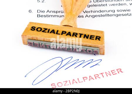Ein Stempel aus Holz liegt auf einem Dokument. Aufschrift: Sozialpartner
