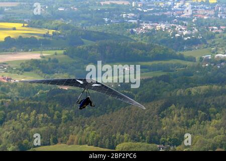 Kozakov, Czech Republic. 16th May, 2020. A Hang-glider steering an ultra light air craft has taken off from Kozakov (100 kilometers north from Prague) in the Czech Republic. Hang gliding is an air sport or recreational activity in which a pilot flies a light, non-motorised foot-launched heavier-than-air aircraft called a hang glider. Typically the pilot is in a harness suspended from the airframe, and controls the aircraft by shifting body weight in opposition to a control frame. Credit: Slavek Ruta/ZUMA Wire/Alamy Live News Stock Photo