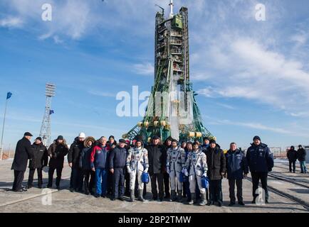 Expedition 58 Crew Wave At the Pad  Expedition 58 crew, Flight Engineer Anne McClain of NASA, Soyuz Commander Oleg Kononenko of Roscosmos, and Flight Engineer David Saint-Jacques of the Canadian Space Agency (CSA) pose for a photo with senior officials of Roscosmos, NASA, and the Canadian Space Agency (CSA) after arriving at the launch pad by bus to begin boarding the Soyuz MS-11 spacecraft for launch, Monday, Dec. 3, 2018 in Baikonur, Kazakhstan. Kononenko, McClain, and Saint-Jacques will spend the next six and a half months onboard the International Space Station. Stock Photo