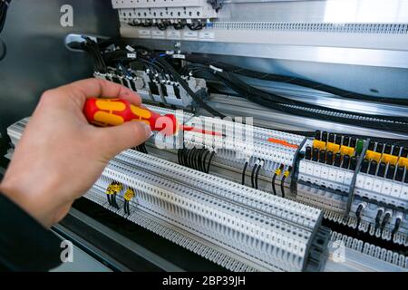 Installing a new connector in electric cubicle. Stock Photo